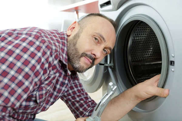 Portrait of mature serviceman by washing machine — Stock Photo, Image