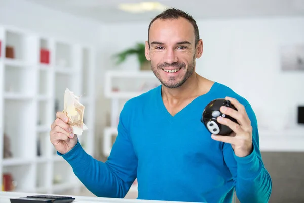 Boldog ember kezében malac bank és bankjegyek — Stock Fotó