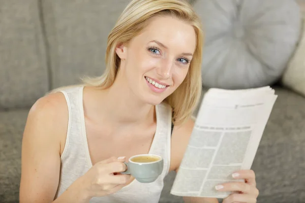 Mulher lendo o jornal em casa e bebendo um café expresso — Fotografia de Stock