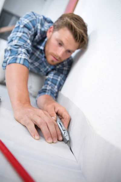 Cutting the excess of the flooring cover — Stockfoto