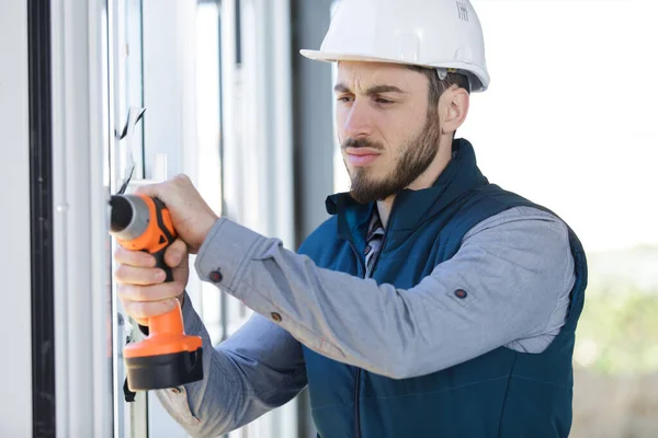 Porträt eines gutaussehenden Reparateurs mit Bohrmaschine — Stockfoto