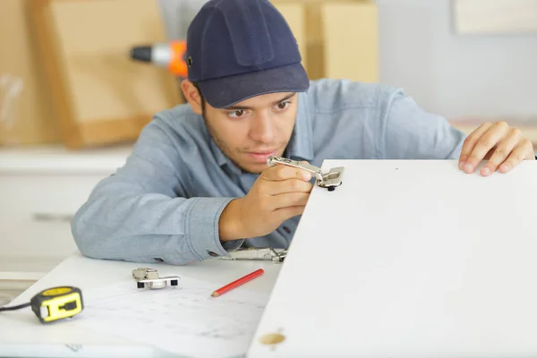 Concentrated man screwing screws into furniture fittings — Stock Photo, Image