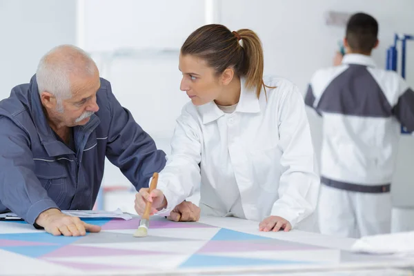 Female artist teaching senior in studio — Stock Photo, Image