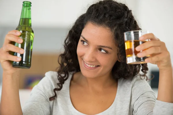 맥주 한 병 과 위스키 한잔을 든 젊은 여자 — 스톡 사진