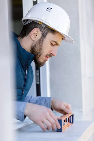 Worker checks the level of a window — Stock Photo, Image