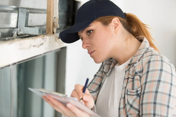 Jonge vrouwelijke supervisor neemt notities — Stockfoto