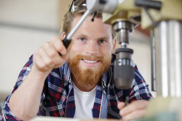 Een gelukkig man met behulp van een houtfreesmachine — Stockfoto