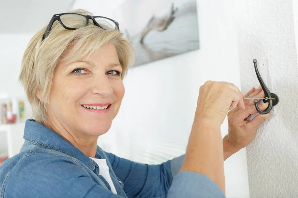 Een oudere vrouw doet diy — Stockfoto