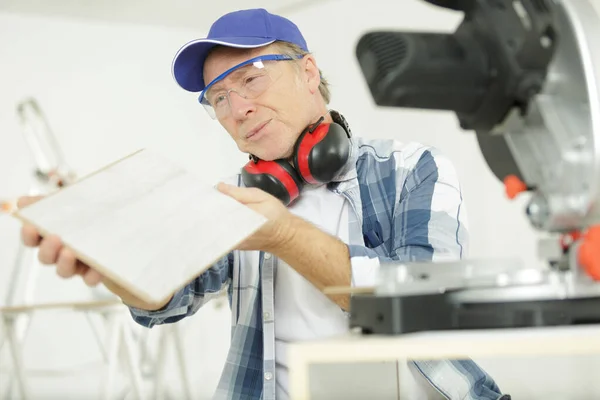 Mature man using circular saw — Stockfoto