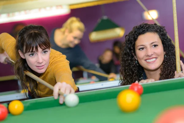 Two young women playing pool — ストック写真