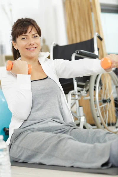 Pozitivní invalidní žena cvičení doma — Stock fotografie