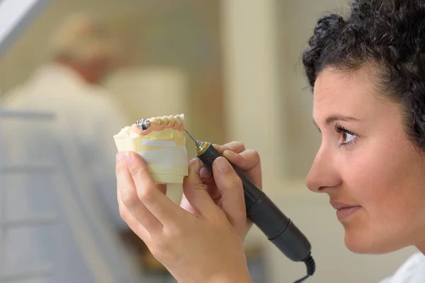 Technician polishing or grinding a dental implant — Stock Photo, Image