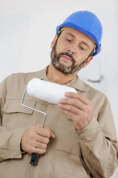 Painter man checking his roller — Stock Photo, Image