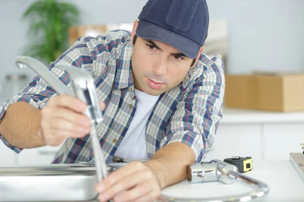 Nahaufnahme eines männlichen Arbeiters, der den Wasserhahn anschließt — Stockfoto