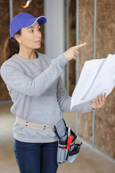 Joven mujer ingeniera activa mirando planos —  Fotos de Stock