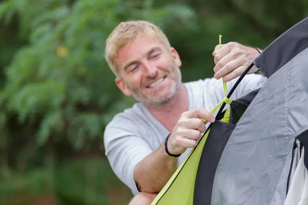 Mann baut Zelt beim Zelten — Stockfoto