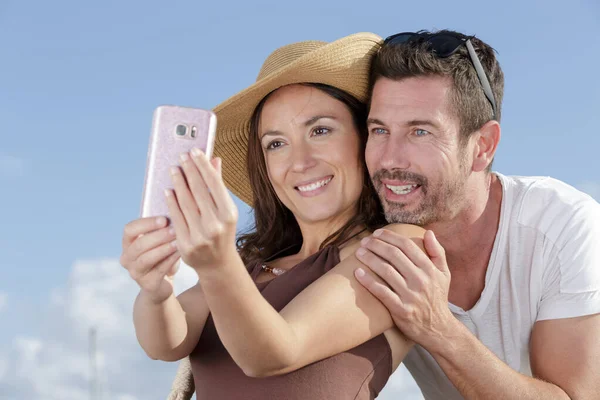 Casal tirando uma selfie na praia — Fotografia de Stock