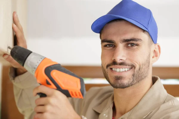 Close portrait of young tradesman using drill — Stock Photo, Image