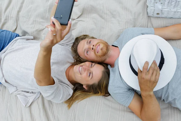 Szczęśliwy piękny para biorąc a selfie z smartphone — Zdjęcie stockowe