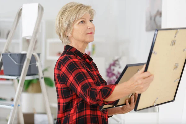 Senior vrouw versieren haar huis — Stockfoto