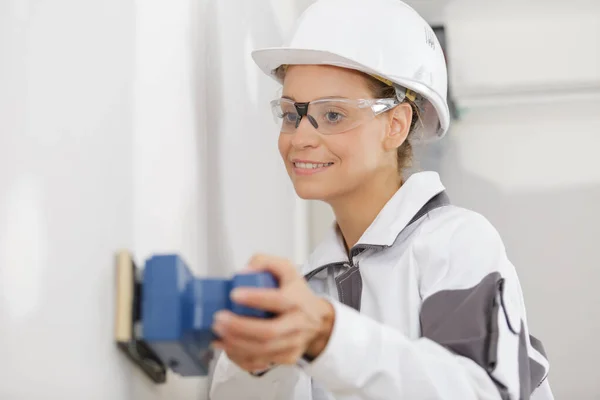 Kvinnliga byggnadsarbetare utjämning vägg yta — Stockfoto