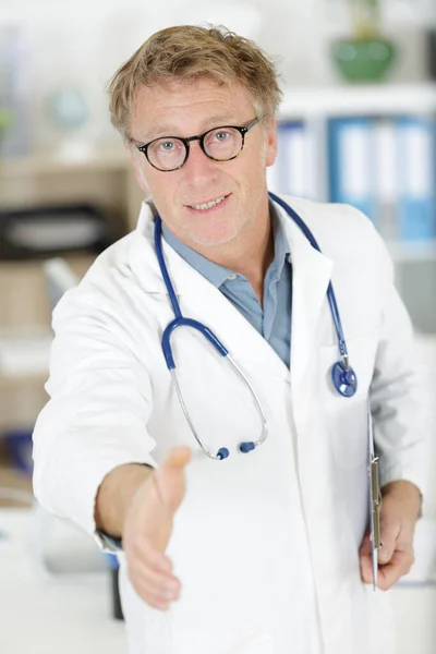 Happy mature man doctor smiling while giving handshake — Stock Photo, Image