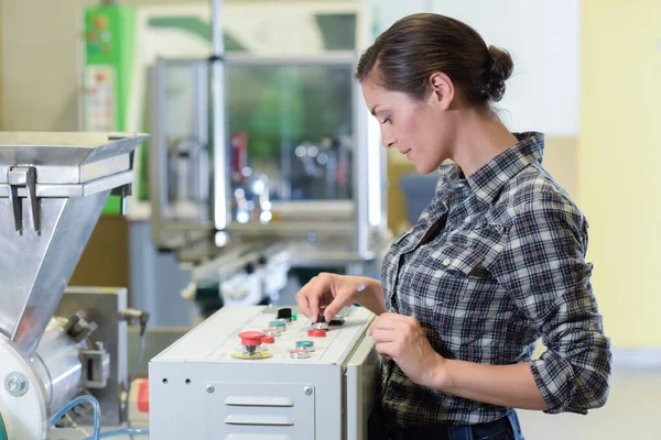 Femme utilisant des machines dans une usine — Photo