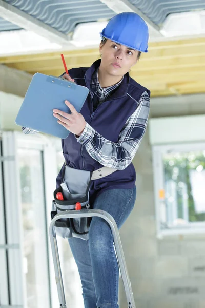 Mulher construtor segurando uma prancheta — Fotografia de Stock