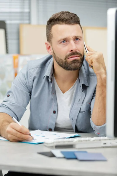 Affärsman att ringa telefonsamtal som sitter vid skrivbord i Office — Stockfoto