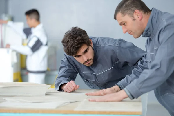Dos carpinteros trabajando con tablón de madera en el taller — Foto de Stock