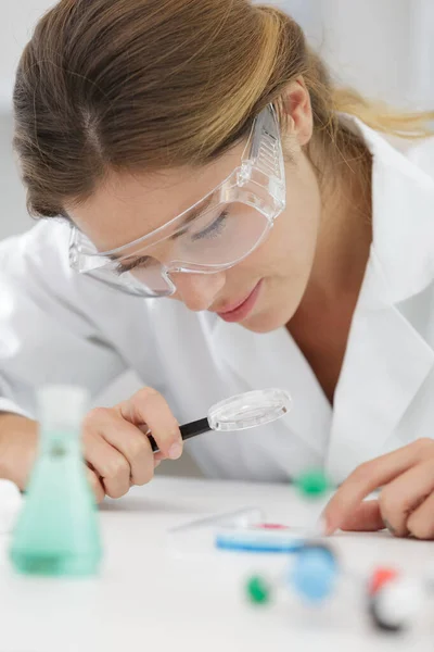 Frau schaut in ein Vergrößerungsglas — Stockfoto