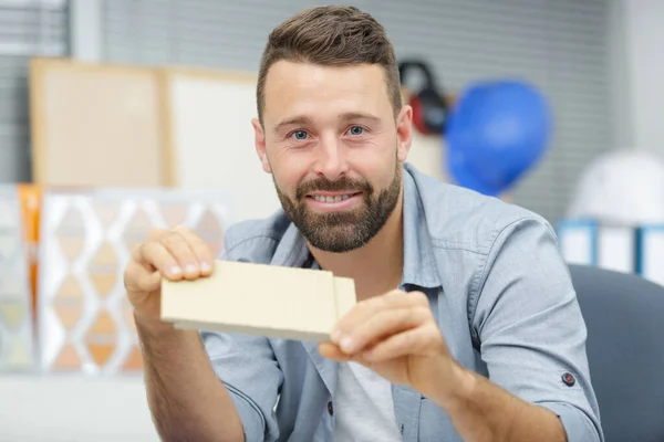 Man working with wood at desk in office — Stock Photo, Image