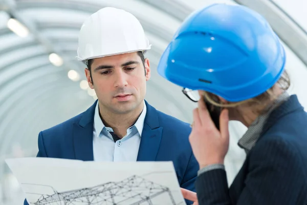 Ingenieur auf einer Baustelle schaut sich Pläne an — Stockfoto