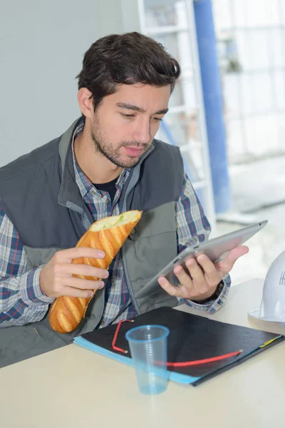 Wesoły pracownik jedzący lunch — Zdjęcie stockowe