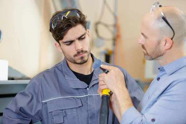 Werklieden controleren pijp in werkplaats — Stockfoto