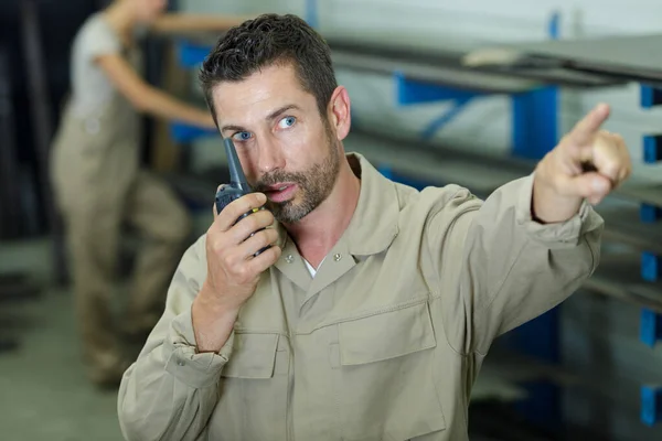 Trabalhador masculino no capacete com walkie talkie no estoque de transporte — Fotografia de Stock