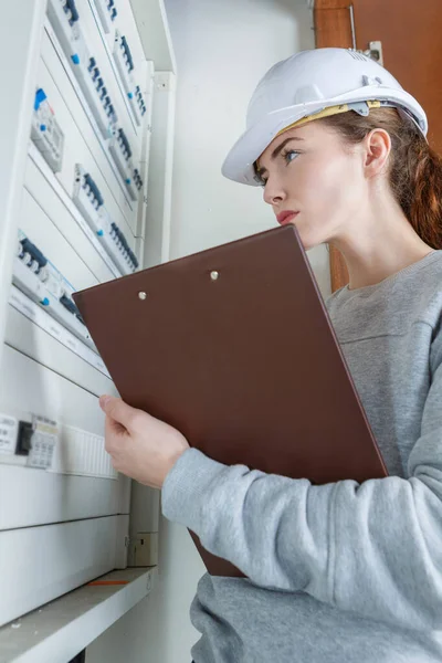 Elektrikerin checkt Sicherungskasten ab — Stockfoto