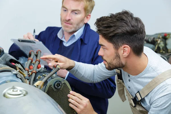 Zwei Mechaniker bauen einen Motor zusammen — Stockfoto