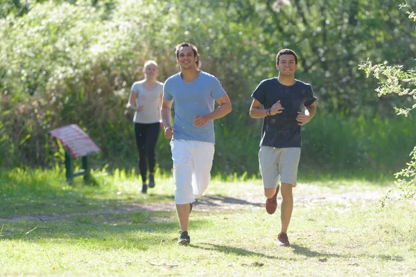 Grupo de personas haciendo ejercicio trotando por el parque juntos — Foto de Stock