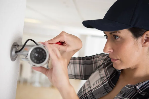 Instalador cctv feminino verificando câmera de segurança — Fotografia de Stock