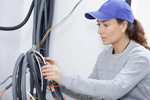 Vrouwelijke elektricien werken met kabels — Stockfoto