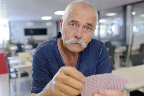 Pensionärer spelkort i ett äldreboende — Stockfoto