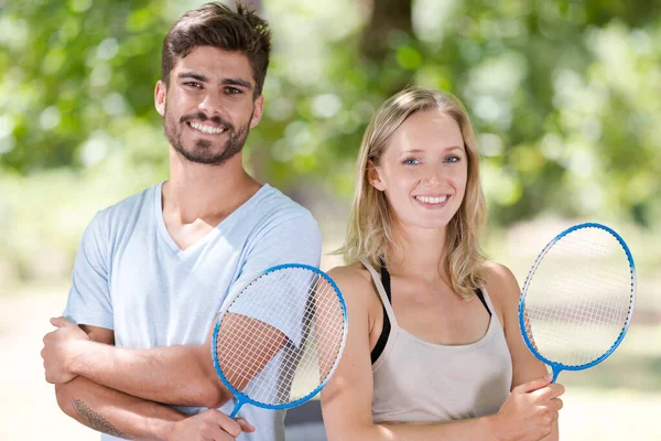 Coppia felice con racchette badminton — Foto Stock