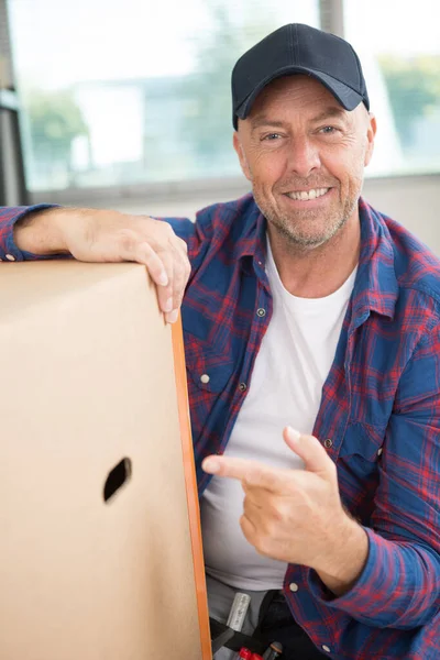 Homem de entrega apontando para pilha de caixas i — Fotografia de Stock