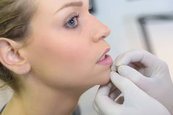 A girl getting a piercing — Stock Photo, Image