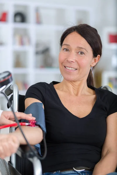 Mujer discapacitada que se mide la presión arterial — Foto de Stock