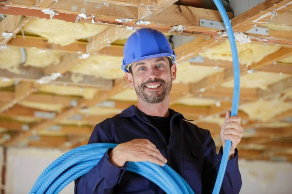 Um construtor com cabos dentro de casa — Fotografia de Stock