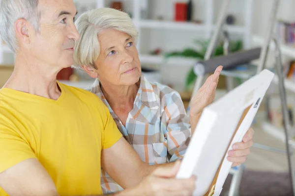 Una pareja de ancianos elegir solución bricolaje — Foto de Stock