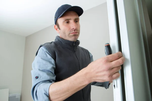 Handyman installera den nya dörrlåset i rummet — Stockfoto