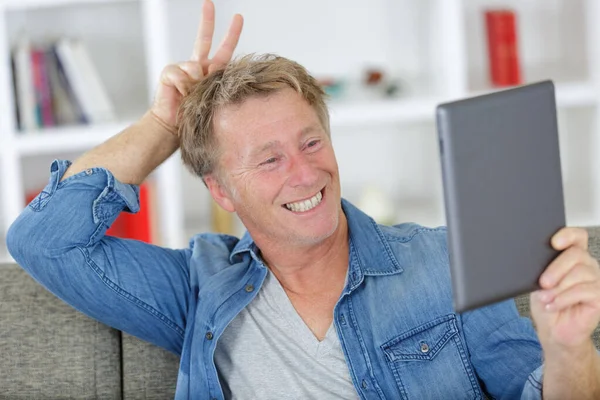 Uomo sorridente che gioca su tablet digitale — Foto Stock